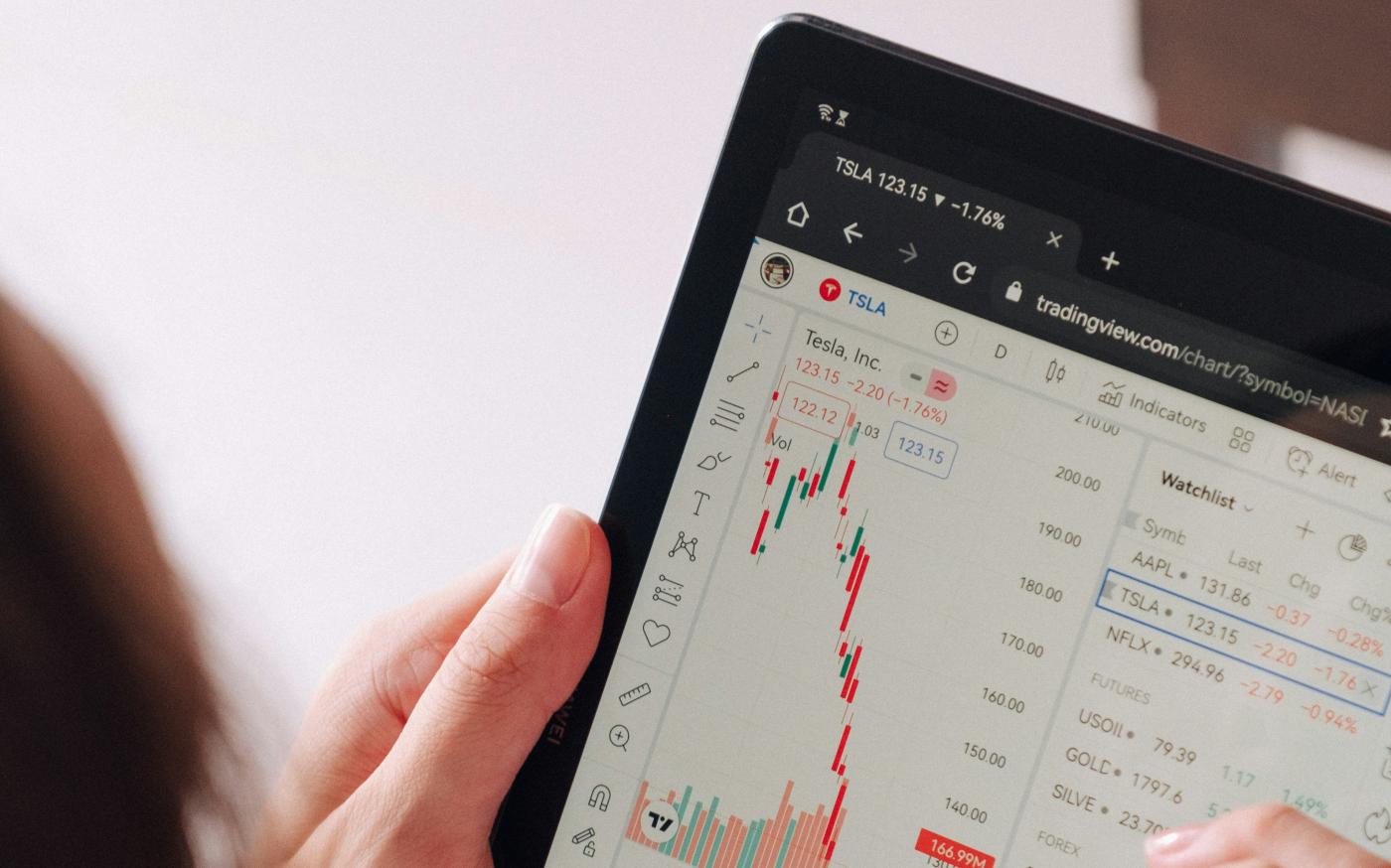 a woman holding a tablet with a chart on it by George Dagerotip courtesy of Unsplash.