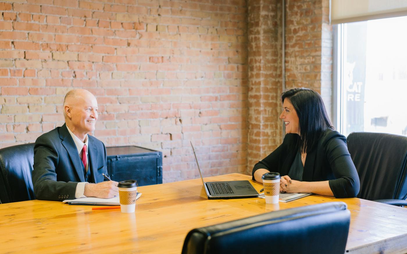 man and woman talking inside office by Amy Hirschi courtesy of Unsplash.