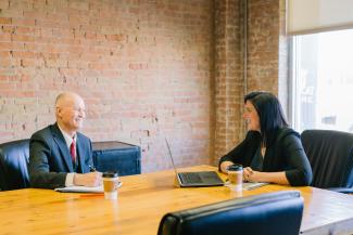 man and woman talking inside office by Amy Hirschi courtesy of Unsplash.